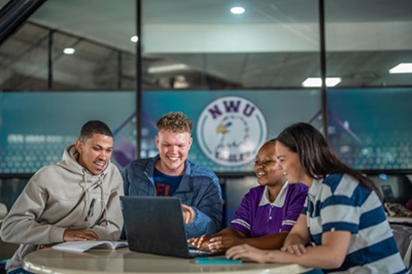 Students sitting and looking at a laptop